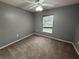 Bedroom featuring a ceiling fan, neutral gray walls, and a window that brings in natural light at 11308 Mahopac Rd, Weeki Wachee, FL 34614