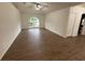 Bright living room featuring hardwood floors, a ceiling fan, and an arched window providing natural light at 11308 Mahopac Rd, Weeki Wachee, FL 34614