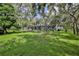 Lush green backyard with an enclosed pool and mature trees at 11510 Lakeview Dr, New Port Richey, FL 34654