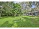 Lush green backyard with mature trees surrounding the back of the home at 11510 Lakeview Dr, New Port Richey, FL 34654
