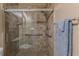 Bathroom shower with glass door, tiled walls, and grab bars for accessibility at 11510 Lakeview Dr, New Port Richey, FL 34654