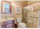Well-lit bathroom featuring a tiled shower with glass door and vanity with wood finish at 11510 Lakeview Dr, New Port Richey, FL 34654