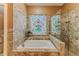 Luxurious bathroom featuring a soaking tub and a stained glass window above the tub at 11510 Lakeview Dr, New Port Richey, FL 34654
