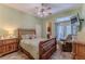 Cozy bedroom features a ceiling fan, tiled floors, and a chair for comfortable living at 11510 Lakeview Dr, New Port Richey, FL 34654