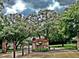 Entrance to the Reserve at Golden Acres community surrounded by mature trees and an ornate wrought iron gate at 11510 Lakeview Dr, New Port Richey, FL 34654