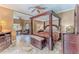 Well-appointed main bedroom featuring a four-poster bed, ample natural light, and tile flooring at 11510 Lakeview Dr, New Port Richey, FL 34654