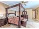 Luxurious main bedroom with a four-poster bed, matching dressers, and serene ambiance at 11510 Lakeview Dr, New Port Richey, FL 34654