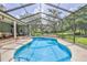 Enclosed screened pool with adjacent patio and view of treed back yard at 11510 Lakeview Dr, New Port Richey, FL 34654