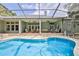 Spacious pool area with a fully screened enclosure, covered patio, and lush landscaping at 11510 Lakeview Dr, New Port Richey, FL 34654