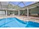Beautiful screened-in pool area with covered patio, lounge furniture and an outdoor cooking station at 11510 Lakeview Dr, New Port Richey, FL 34654