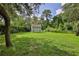 Backyard shed featuring a well-manicured lawn with surrounding trees at 11510 Lakeview Dr, New Port Richey, FL 34654