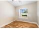 Cozy and bright bedroom with hardwood floors and a large window offering pleasant outdoor views at 12026 Penguin Ave, Weeki Wachee, FL 34614