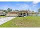 Charming single-story home featuring a well-manicured lawn and an attached two-car garage at 12026 Penguin Ave, Weeki Wachee, FL 34614