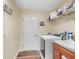 Laundry room with modern washer, dryer, and a storage shelf at 12026 Penguin Ave, Weeki Wachee, FL 34614