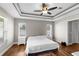 A well-lit main bedroom with a ceiling fan and two windows; light gray walls, white trim, and wood-look flooring at 12026 Penguin Ave, Weeki Wachee, FL 34614