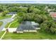 Aerial view of the home showing the backyard with screened-in patio, and mature trees at 12060 Sapphire Dr, Spring Hill, FL 34609