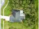 An aerial view of a home with a large yard, screened patio, and a driveway with a walkway at 12060 Sapphire Dr, Spring Hill, FL 34609