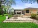 The backyard boasts a stone patio with a fire pit, screened-in lanai, and lush greenery at 12060 Sapphire Dr, Spring Hill, FL 34609