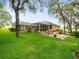 Expansive backyard featuring a screened-in lanai, patio area, and meticulously manicured lawn at 12060 Sapphire Dr, Spring Hill, FL 34609