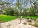 The backyard is complete with a stone fire pit, patio area, and mature trees at 12060 Sapphire Dr, Spring Hill, FL 34609