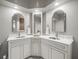 Elegant bathroom with dual sinks, white cabinetry, framed mirrors and stylish fixtures at 12060 Sapphire Dr, Spring Hill, FL 34609