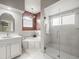 Luxurious bathroom showcasing a bathtub, glass shower, decorative lighting, and white vanity at 12060 Sapphire Dr, Spring Hill, FL 34609