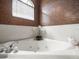 Elegant bathroom showcasing a soaking tub with tile surround, window and bronze accent wall at 12060 Sapphire Dr, Spring Hill, FL 34609