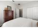 Bright bedroom showcasing wood floors, neutral walls, wood dresser, and access to en-suite bathroom at 12060 Sapphire Dr, Spring Hill, FL 34609