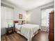Bedroom with wood floors, neutral walls, two windows with blinds, and classic wood furnishings at 12060 Sapphire Dr, Spring Hill, FL 34609
