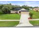 Attractive single-story home boasts a lush green lawn, tidy landscaping, and three car garage at 12060 Sapphire Dr, Spring Hill, FL 34609