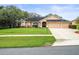 Charming single-story home with well-manicured lawn, three-car garage, and double door entry at 12060 Sapphire Dr, Spring Hill, FL 34609