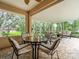 Covered lanai featuring brick flooring, outdoor seating, and a view of the landscaped backyard at 12060 Sapphire Dr, Spring Hill, FL 34609