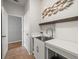 Bright laundry room features white cabinetry, a stainless steel sink, stylish decor, and tile flooring at 12060 Sapphire Dr, Spring Hill, FL 34609