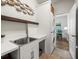 Bright laundry room features white cabinetry, stacked washer/dryer, a stainless steel sink, and access to an office space at 12060 Sapphire Dr, Spring Hill, FL 34609