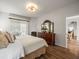 Bright main bedroom with a large bed, dresser with mirror, and access to a private patio at 12060 Sapphire Dr, Spring Hill, FL 34609