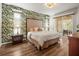 Spacious main bedroom featuring leafy wallpaper, king bed, and private access to an outdoor patio at 12060 Sapphire Dr, Spring Hill, FL 34609