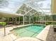 Pool area with a screened enclosure, brick pavers, and outdoor seating at 12060 Sapphire Dr, Spring Hill, FL 34609