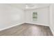 Bright, empty bedroom features a ceiling fan, neutral paint, wood-look flooring, and a window with outside view at 12420 Talpa St, Spring Hill, FL 34608