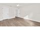 Light-filled empty bedroom showcasing wood floors, a ceiling fan, white paint, and two white doors at 12420 Talpa St, Spring Hill, FL 34608