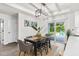 Bright dining area featuring a modern chandelier, table with seating for six, and sliding glass doors to the backyard at 12420 Talpa St, Spring Hill, FL 34608