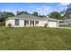 New construction home features a well-maintained lawn, white siding, gray roof, and blue trim at 12420 Talpa St, Spring Hill, FL 34608