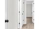 Hallway with multiple white doors showcases modern black hardware and wood-look flooring at 12420 Talpa St, Spring Hill, FL 34608