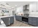 Modern kitchen with stainless steel appliances, gray and white cabinets, quartz counters and stylish range hood at 12420 Talpa St, Spring Hill, FL 34608