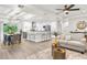 Open-concept living space featuring modern kitchen with island, dining area, and cozy living room with neutral decor and ample lighting at 12420 Talpa St, Spring Hill, FL 34608