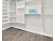 Spacious walk-in closet with adjustable shelving and gray vinyl flooring at 12420 Talpa St, Spring Hill, FL 34608
