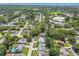Aerial view of a neighborhood with tree-lined streets, pools, and waterways in the distance at 1265 Royal Oak Dr, Dunedin, FL 34698