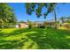 Expansive backyard with a large grassy area, shed, and a view of the screened-in porch at 1265 Royal Oak Dr, Dunedin, FL 34698