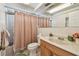 Traditional bathroom featuring a vanity, toilet, and shower with peach-colored curtain at 1265 Royal Oak Dr, Dunedin, FL 34698