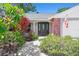 Charming home featuring a black front door with decorative glass and beautiful landscaping at 1265 Royal Oak Dr, Dunedin, FL 34698