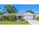 Charming single-story home with brick accents, lush landscaping, and a well-maintained front yard at 1265 Royal Oak Dr, Dunedin, FL 34698